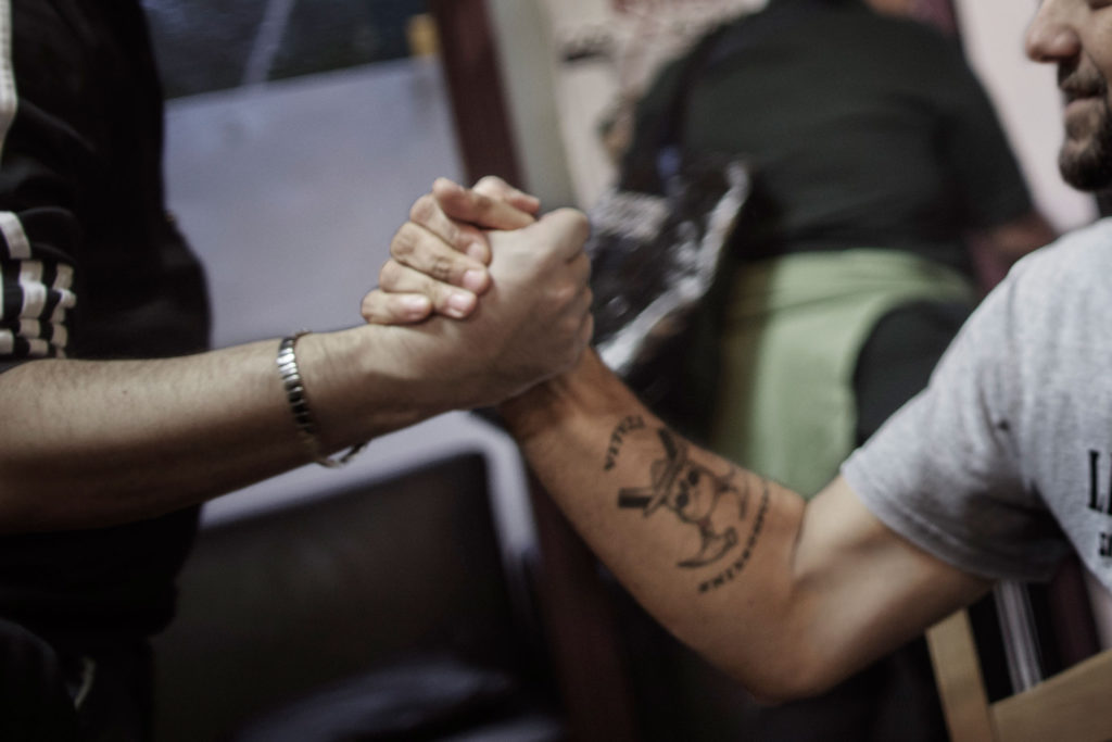 Riccardo företräder Lealtà e Azione. Tatueringen på armen syns även inom den nynazistiska sammanslutningen Hammerskin.