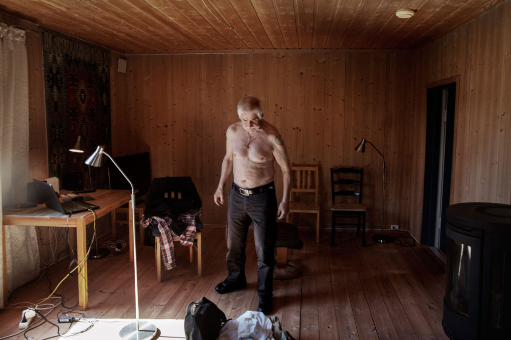 Tore Tvedt tar av sig kläderna i vardagsrummet, på gården utanför Notodden, för att klä sig i dräkten han bar när han utförde de fornnordiska ritualerna som gjorde Vigrid riksbekant på 90-talet.